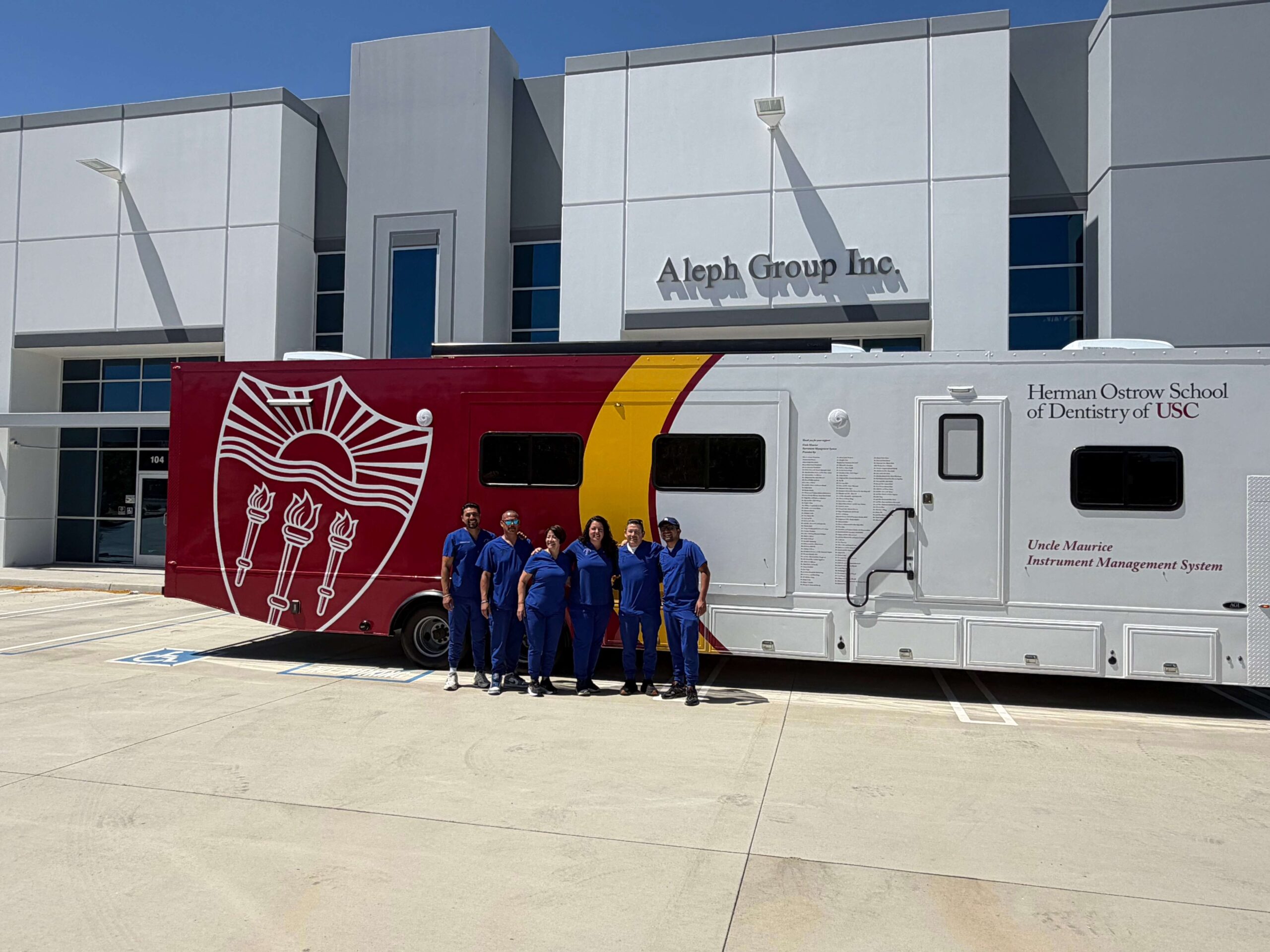 Herman Ostrow School of Dentistry of USC Mobile Dental Clinic Staff Posing for Photo in Front of the New Instrument Sterilization Trailer